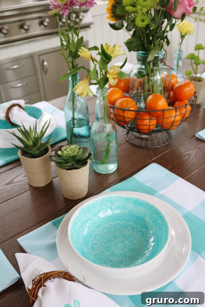 Close-up of white and teal melamine dishes on an outdoor dining table with farmhouse style.