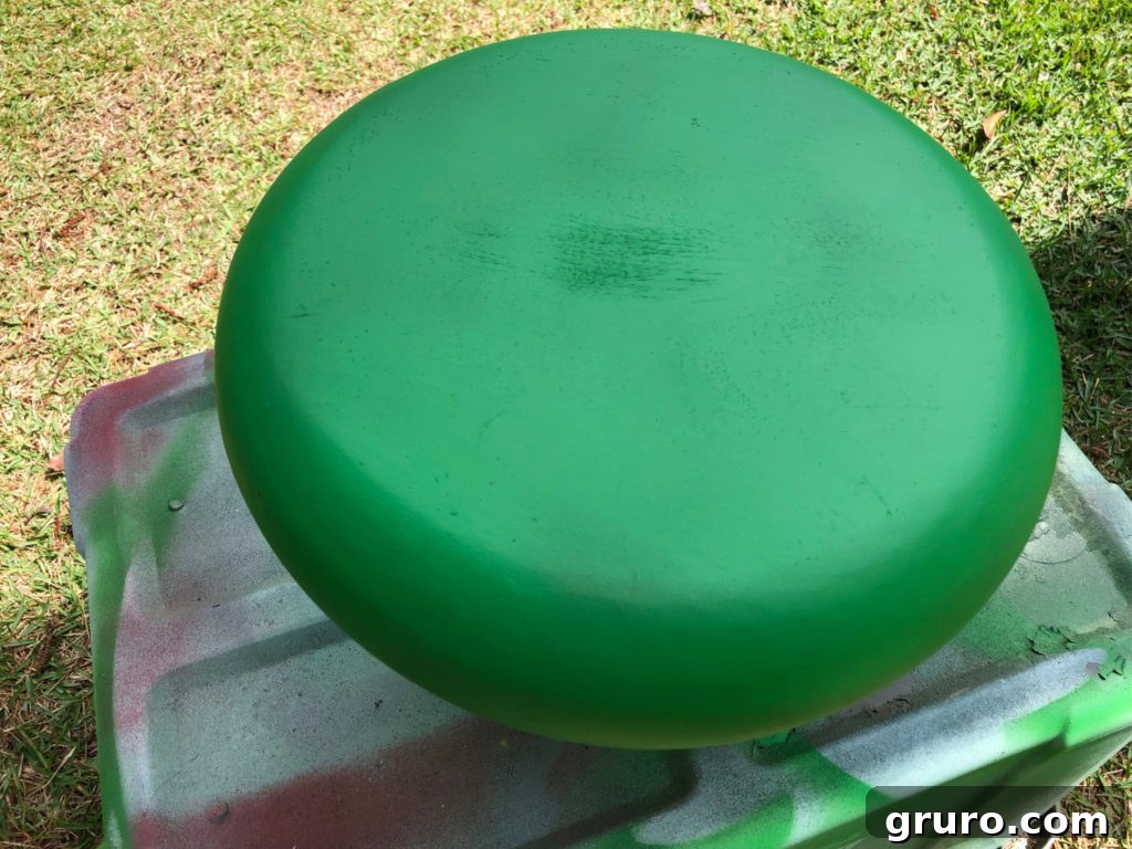 Green exterior of vintage wood bowl being spray painted