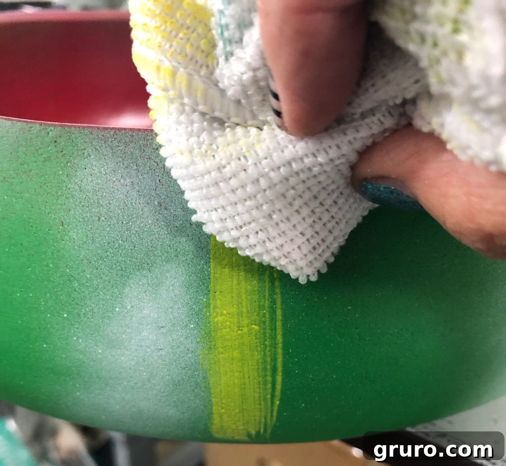 Blending yellow paint with a cloth on the watermelon bowl