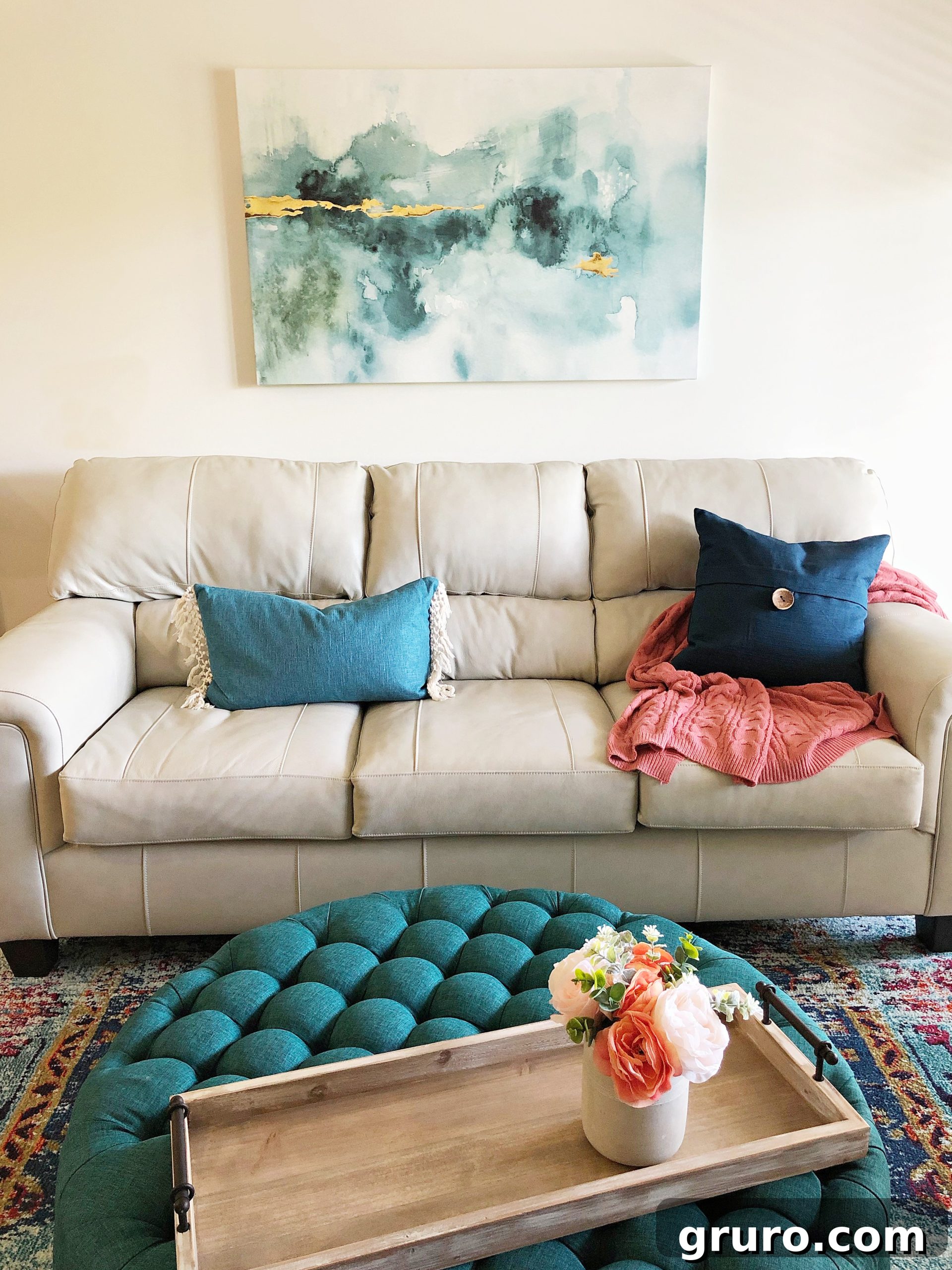 Various teal living room accents, including decorative pillows and throws, harmonizing with the overall lake condo theme.