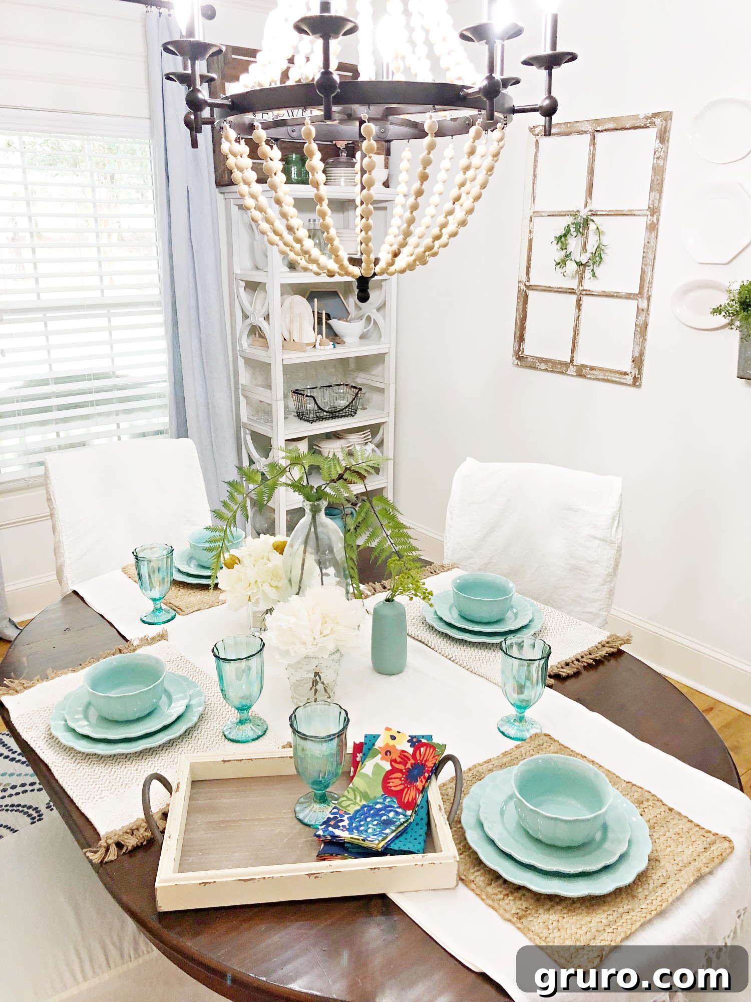 A charming vintage farmhouse table setting, meticulously arranged with colorful dinnerware, elegant pearlized goblets, and vibrant cloth napkins, creating a cohesive and inviting visual.