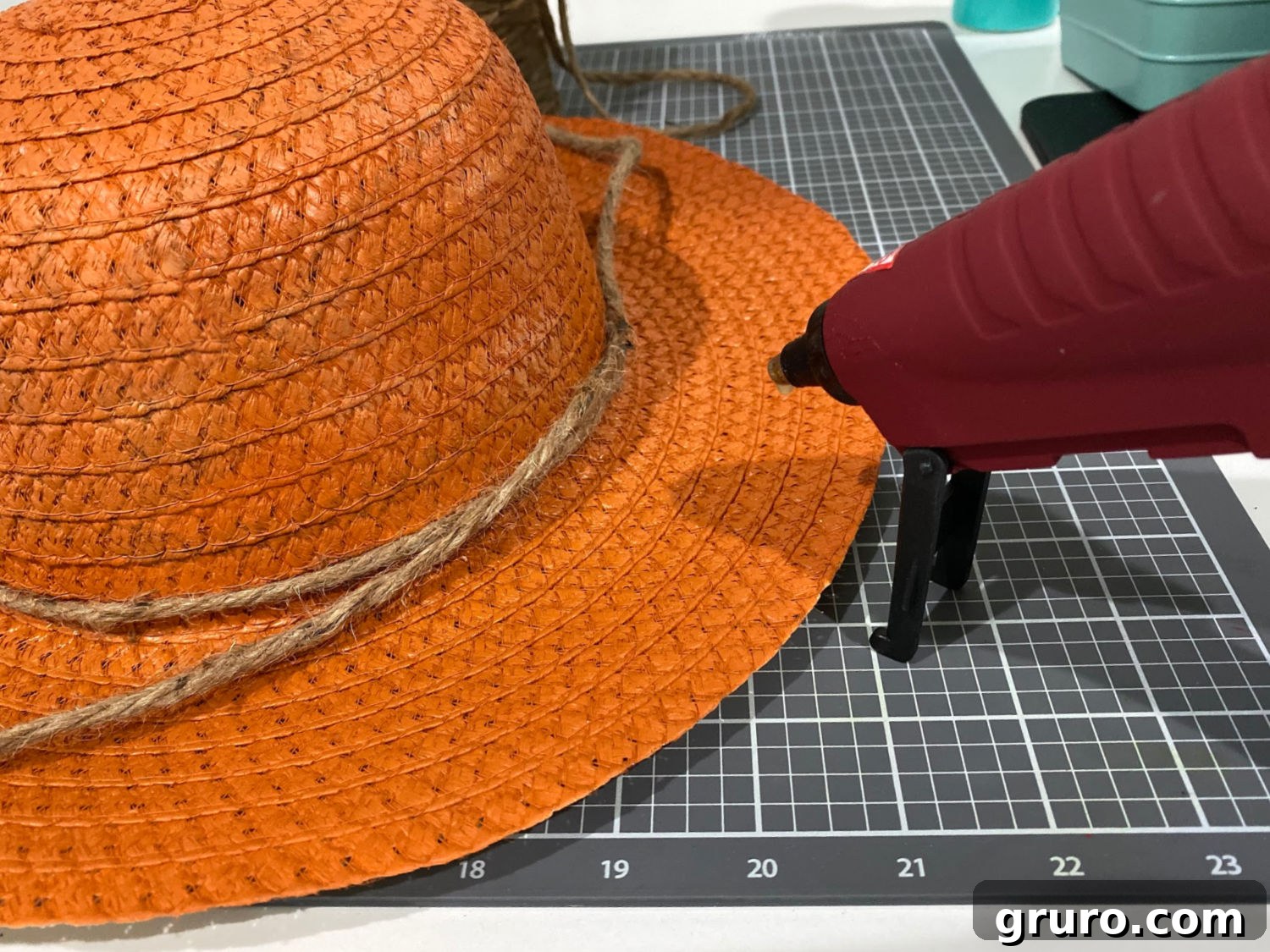 Warm Fall Pumpkin Door Welcome 6 Applying twine to a hat with hot glue to create pumpkin ridges