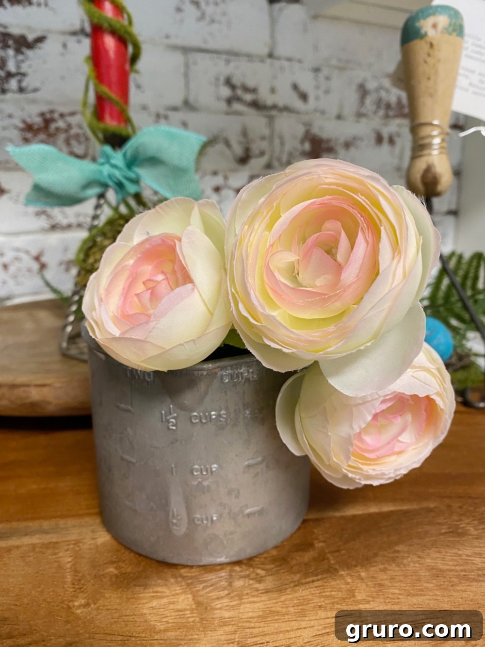 Tin measuring cup repurposed as a small vase for spring flowers