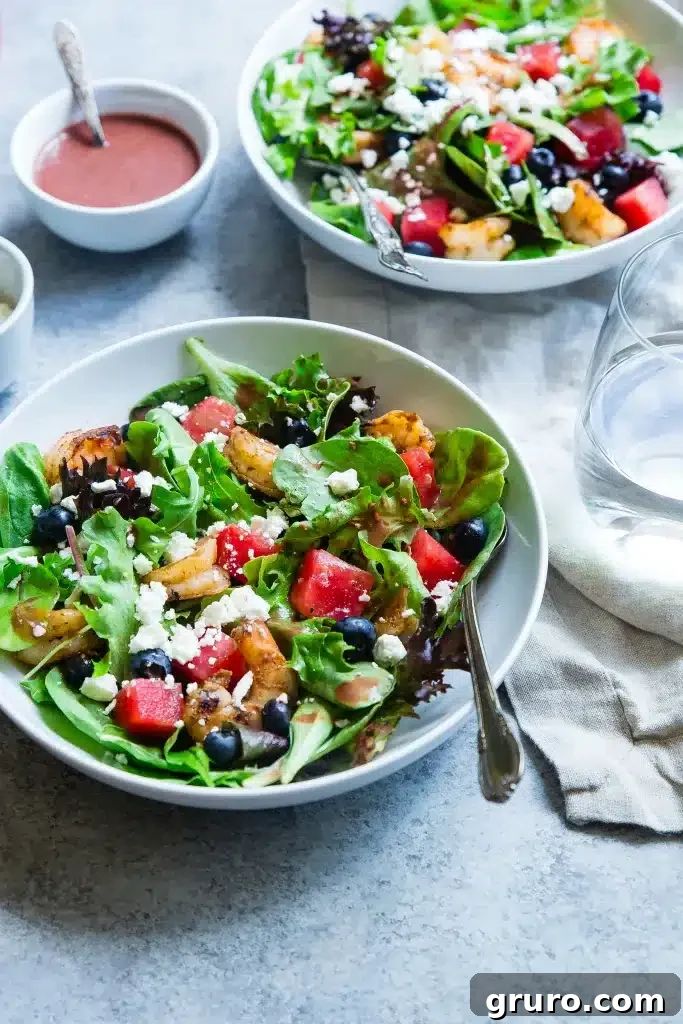 A close-up of a vibrant summer salad with mixed greens, colorful vegetables, and a light dressing.