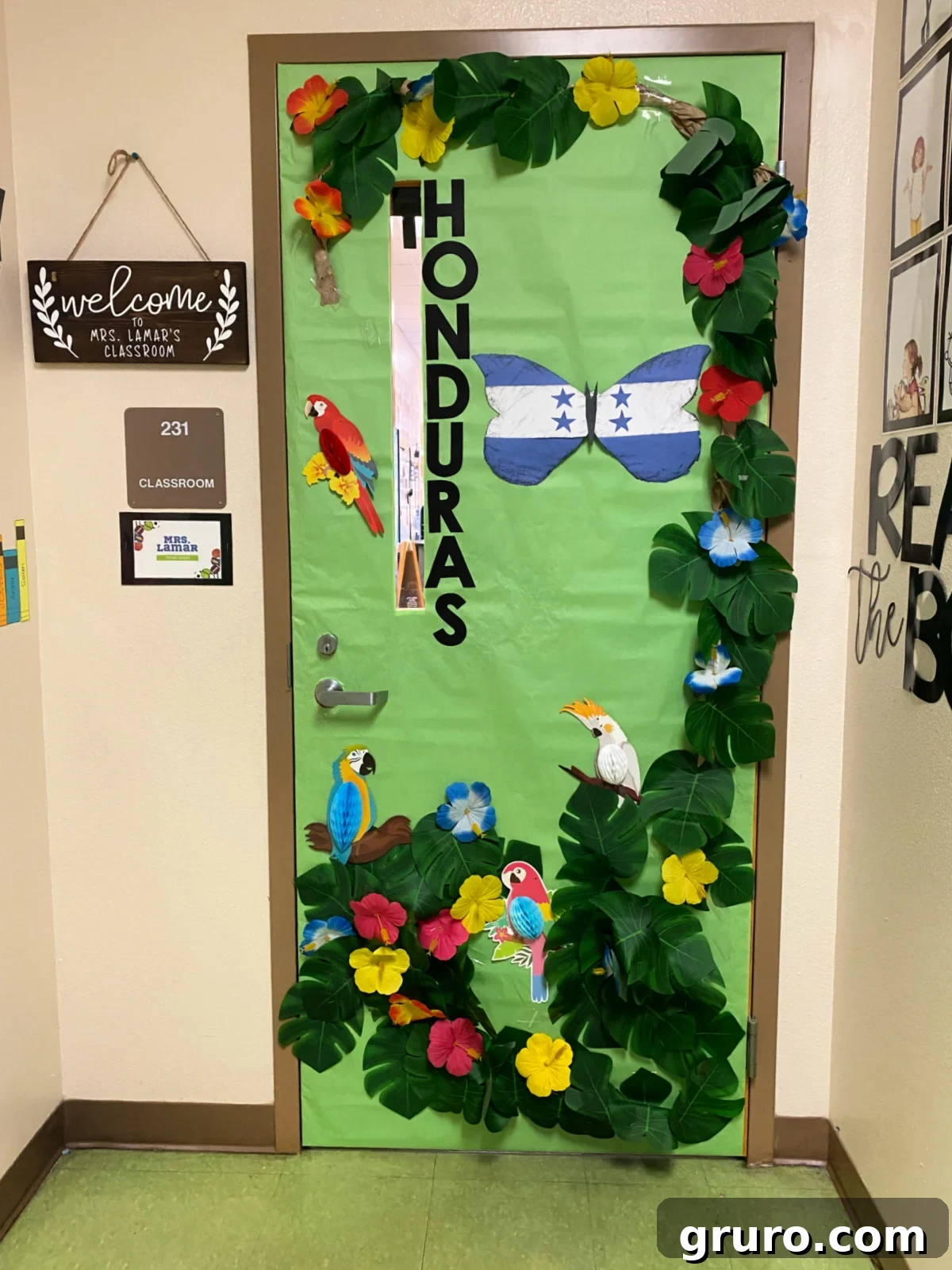 Hispanic Heritage Month Door Decor Ideas 14 Green classroom door with leaves, flowers, and birds with the words 'Honduras' on the door.